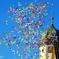 Farverige balloner stiger op ved kirketårn