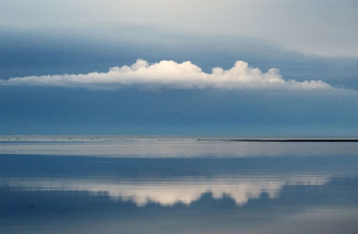 Skyer spejler sig i havet