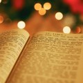 Opslået Bibel med julelys i baggrunden